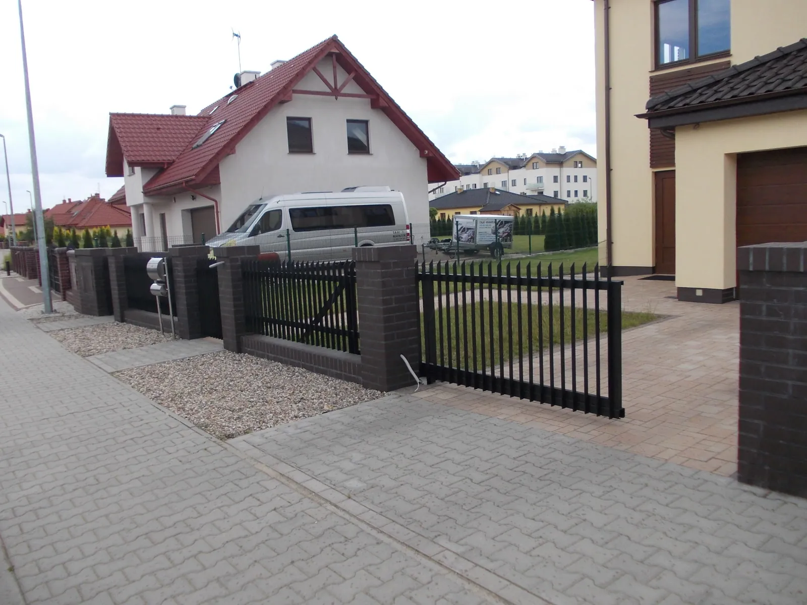 Ogrodzenie z czarnych profili z furtką i bramą przesuwną